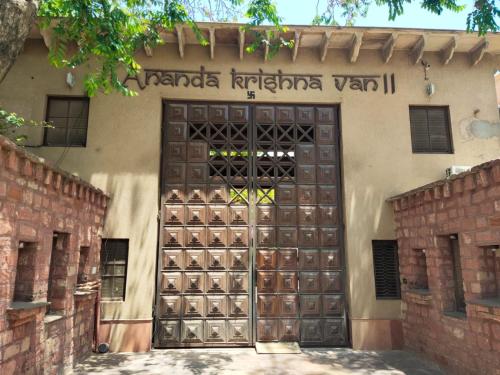 a wooden door with a bunch of wine bottles on it at Ananda Krishna Van in Vrindāvan