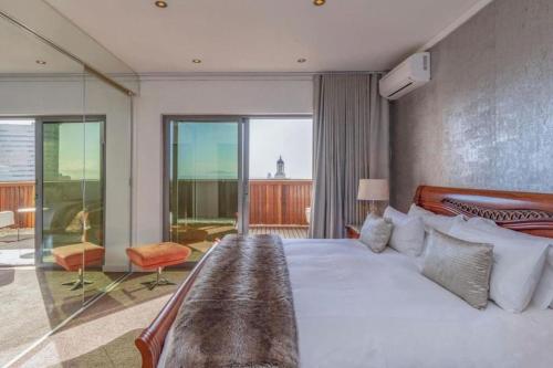 a bedroom with a large bed and a balcony at ICON Living in Cape Town