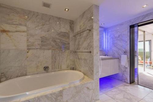 a large bathroom with a tub and a sink at ICON Living in Cape Town