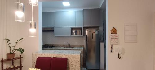 a kitchen with blue cabinets and a stainless steel refrigerator at Apartamento Atos Ubatuba in Sao Paulo