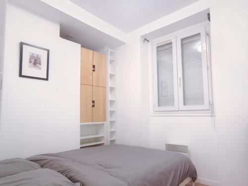 une chambre avec un lit et une fenêtre dans l'établissement Charmant appartement proche de la Tour Eiffel, à Paris