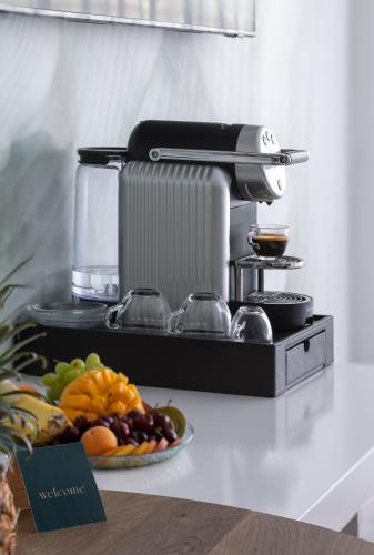 a mixer on a counter with a plate of fruit at AKOYA HOTEL in Eilat