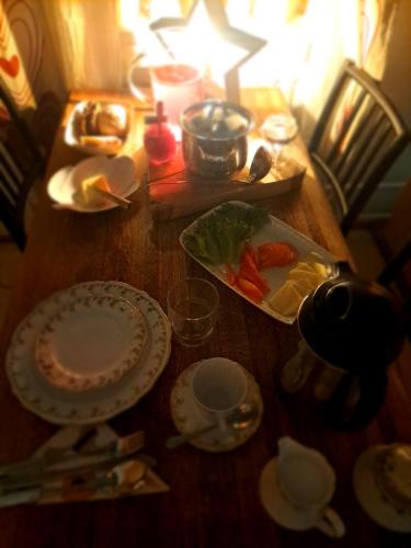 uma mesa de madeira com pratos de comida em Northernlight guesthouse em Kuusamo