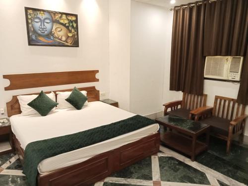 a hotel room with a bed and a chair at Ananda Krishna Van in Vrindāvan