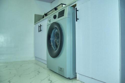 eine Waschmaschine in einer weißen Waschküche in der Unterkunft JKA1-Bedroom Luxury Serviced Apartment in Lagos