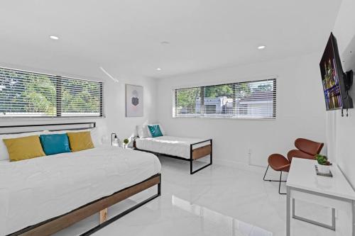 ein weißes Schlafzimmer mit einem Bett und einem Sofa in der Unterkunft Modern Home, Heated Pool Hot-Tub, 12min to Ocean in Miami