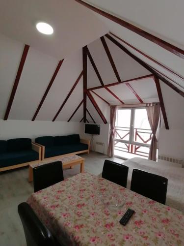 Zimmer mit einem Tisch und Stühlen sowie einem großen Fenster in der Unterkunft Gondola 22 in Kopaonik