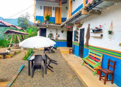 un patio con sillas y una mesa con sombrilla en Casa Viva Alojamiento Rural en Jardín