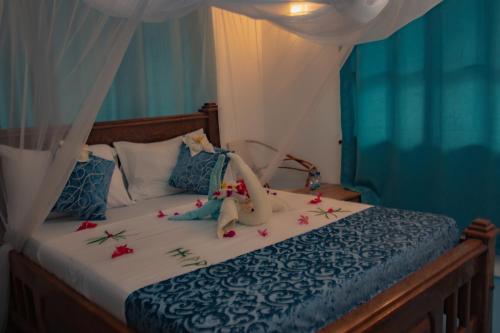 a bedroom with a bed with flowers on it at HA Beach Hotel Zanzibar in Jambiani