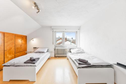 two beds in a white room with a window at MONTEURWOHNUNG in Ebersbach EB01 RAUMSCHMIDE Apartments in Ebersbach an der Fils