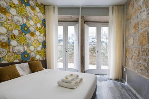 um quarto com uma cama e uma parede com placas em Aposentus - St Francisco Studio 20 no Porto