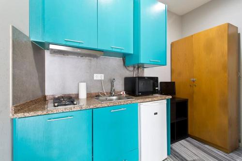 uma cozinha com armários azuis e um lavatório em Aposentus - St Francisco Studio 20 no Porto