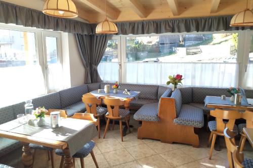 a restaurant with tables and chairs in a room at PANORAMA SportHOTEL in Folgaria