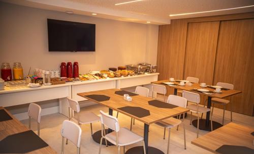 a restaurant with tables and chairs and a counter with food at Aero Hotel in Lauro de Freitas
