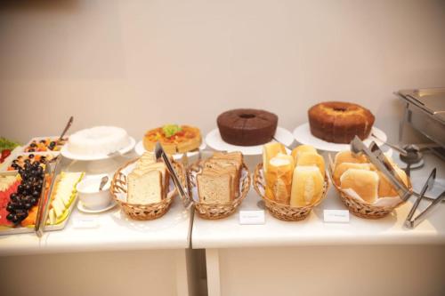 a table with many different types of cakes and pastries at Aero Hotel in Lauro de Freitas