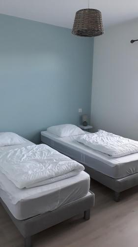 2 Betten nebeneinander in einem Zimmer in der Unterkunft Un petit coin de paradis in Barbâtre