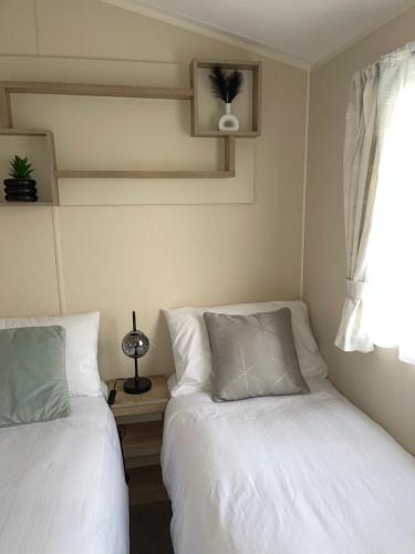 1 dormitorio con 2 camas y ventana en Luxury Hot Tub Caravan Tattershall, en Tattershall