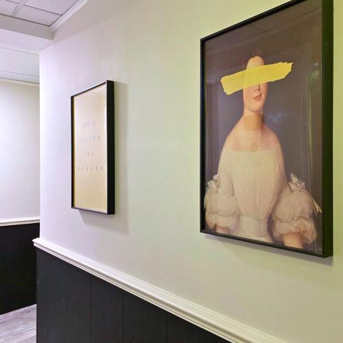 a painting of a woman with a hat on a wall at Pillows CoLiving in Hong Kong