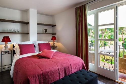 a bedroom with a bed with a red blanket and a window at Wein und Landhaus Kallfels in Kröv