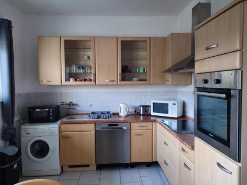 eine Küche mit Holzschränken, einer Waschmaschine und einem Trockner in der Unterkunft Monteurwohnung 6 P. Mönchengladbach Rheydt in Mönchengladbach