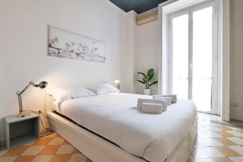 um quarto branco com uma cama grande e um candeeiro em Primopiano - Giacosa em Milão