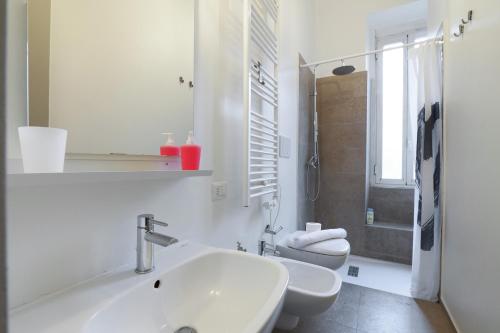 uma casa de banho branca com um lavatório e um WC em Primopiano - Giacosa em Milão