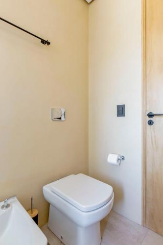 a bathroom with a white toilet and a sink at Rancho Adobe Eco Hotel in Tupungato
