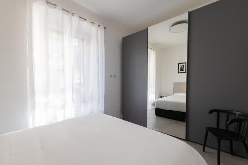 sypialnia z białym łóżkiem i oknem w obiekcie Rivin Apartment w Mediolanie