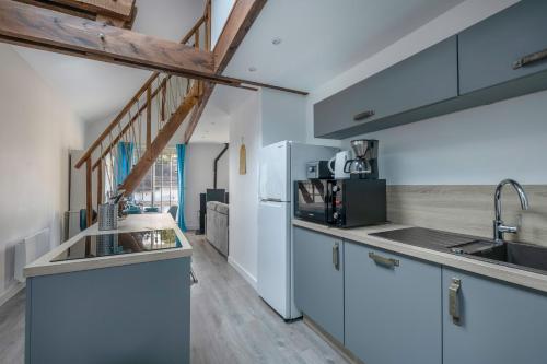 une cuisine avec des armoires blanches et un plancher en bois dans l'établissement Appartement pour 4 - 300m de la plage de la Baule, à La Baule