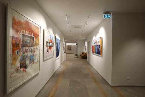 a hallway with paintings on the walls of a building at Soul Art Hotel in Naples