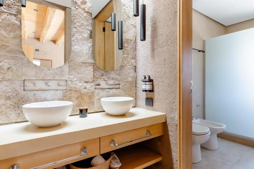 a bathroom with two sinks on a counter with a mirror at Rancho Adobe Eco Hotel in Tupungato
