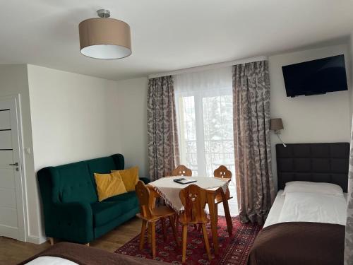 a bedroom with a table and a bed and a couch at Villa Słonecznego Wzgórza in Zakopane