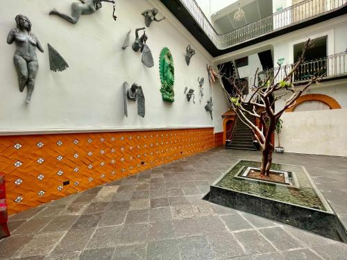 a room with a wall with a tree and sculptures on the wall at Hotel Puebla Plaza in Puebla