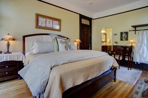 a bedroom with a large bed and a table at Azalea Inn and Villas in Savannah