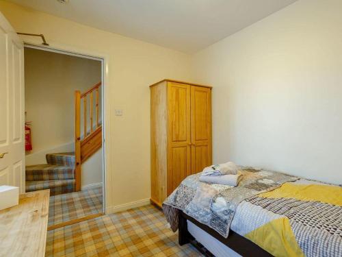 a bedroom with a bed and a closet and a staircase at Craiglea Lodge in Latheron