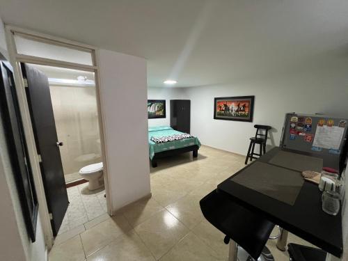 a room with a bathroom with a bed and a desk at APARTAESTUDIO ESPACIOSO Y COMODO in Cali