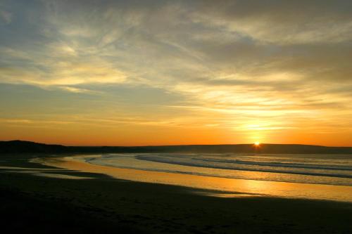 a sunset on a beach with the ocean at Craiglea Lodge in Latheron