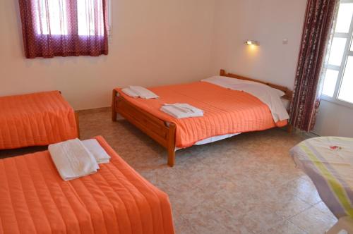 a bedroom with two beds and a mirror at Beach Bungalows in Kypseli