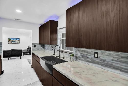 a kitchen with a sink and wooden cabinets at South Florida Splendor - Pool Home in Hollywood