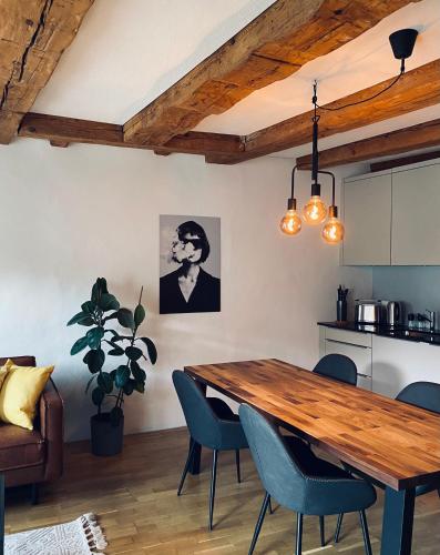 uma cozinha e sala de jantar com uma mesa de madeira e cadeiras em Charmante Altstadtwohnung 3 OG em Solothurn