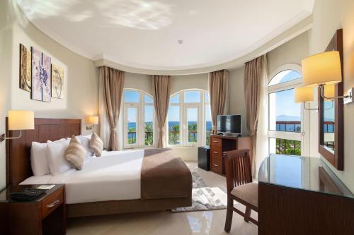 a bedroom with a bed and a tv and windows at Sultan Gardens Resort in Sharm El Sheikh