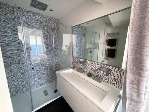 une salle de bain avec un lavabo et un grand miroir dans l'établissement Stunning 2 bedroom flat with sea view on Croisette, à Cannes