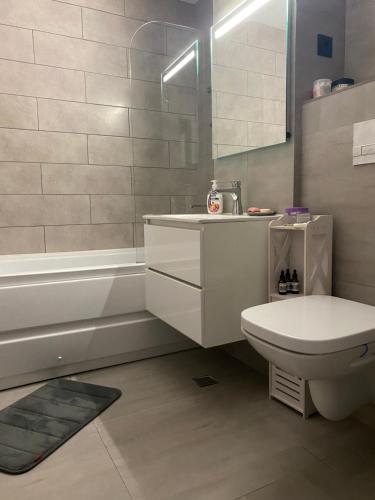 a bathroom with a toilet and a sink and a tub at Apartament UltraLux cu 3 camere in Craiova