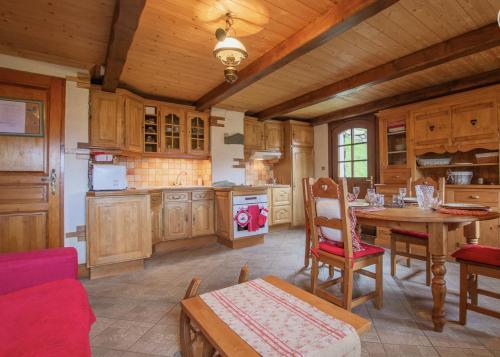 - une cuisine avec des placards en bois et une table dans une pièce dans l'établissement Chalet Le Corti à Crest-Voland-Cohennoz, à Cohennoz