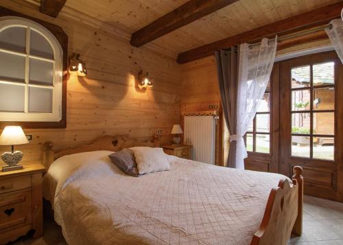 une chambre avec un lit dans une cabane en bois dans l'établissement Chalet Le Corti à Crest-Voland-Cohennoz, à Cohennoz