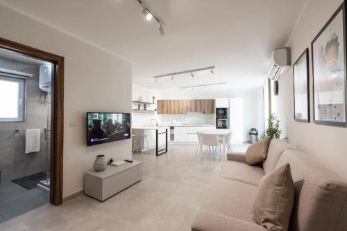 a living room with a couch and a tv at Wait and Sea in Taʼ Xbiex