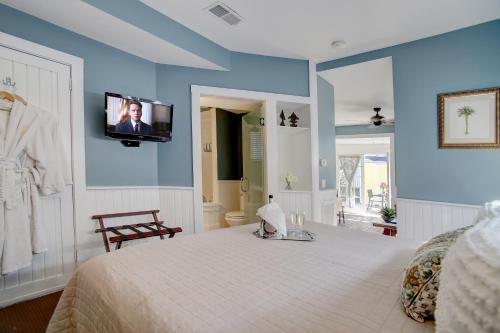 a bedroom with a bed with a tv on the wall at Azalea Inn and Villas in Savannah