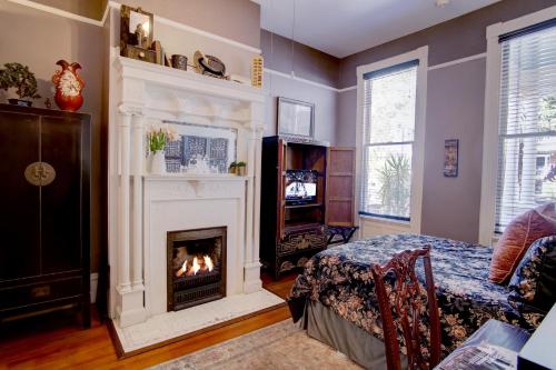 a living room with a fireplace and a bed at Azalea Inn and Villas in Savannah