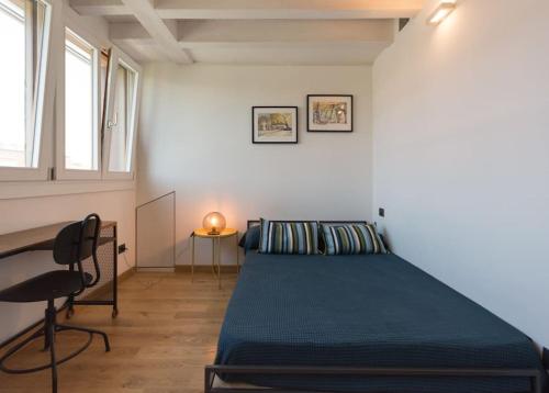 een slaapkamer met een bed, een bureau en een stoel bij attico in un'oasi di verde sui navigli in Milaan