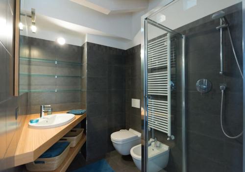 een badkamer met een toilet, een wastafel en een douche bij attico in un'oasi di verde sui navigli in Milaan